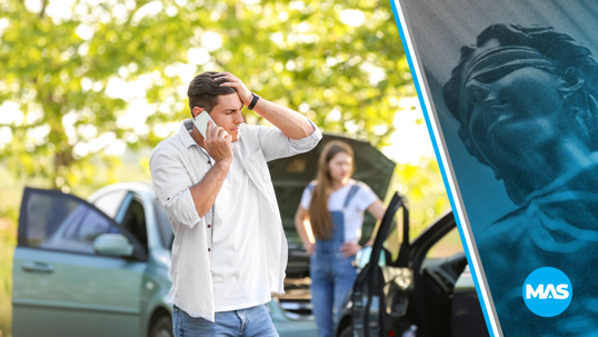 Man talking on the phone after a car accident.